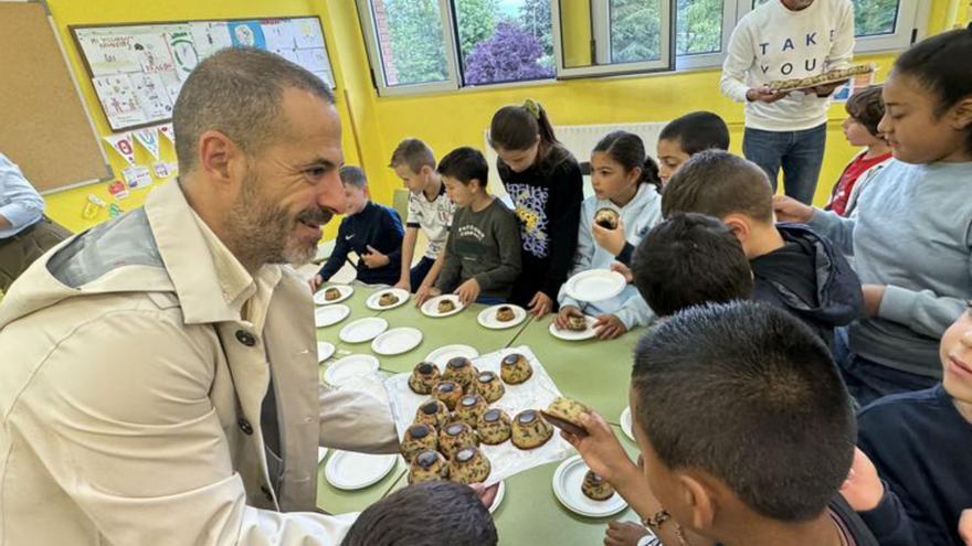Ángel García ofrece dulces a los niños del colegio Santa Bárbara de Lugones. | A. S.