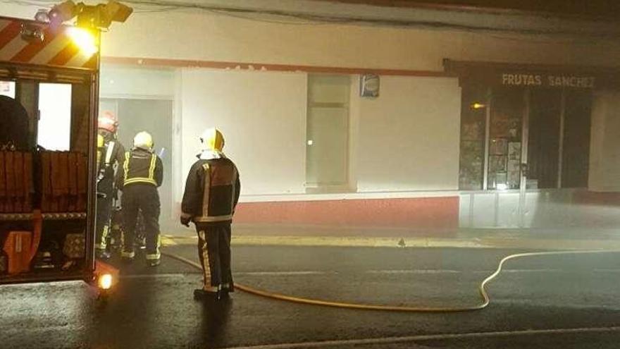 Bomberos en la extinción del incendio en la frutería de Sada.