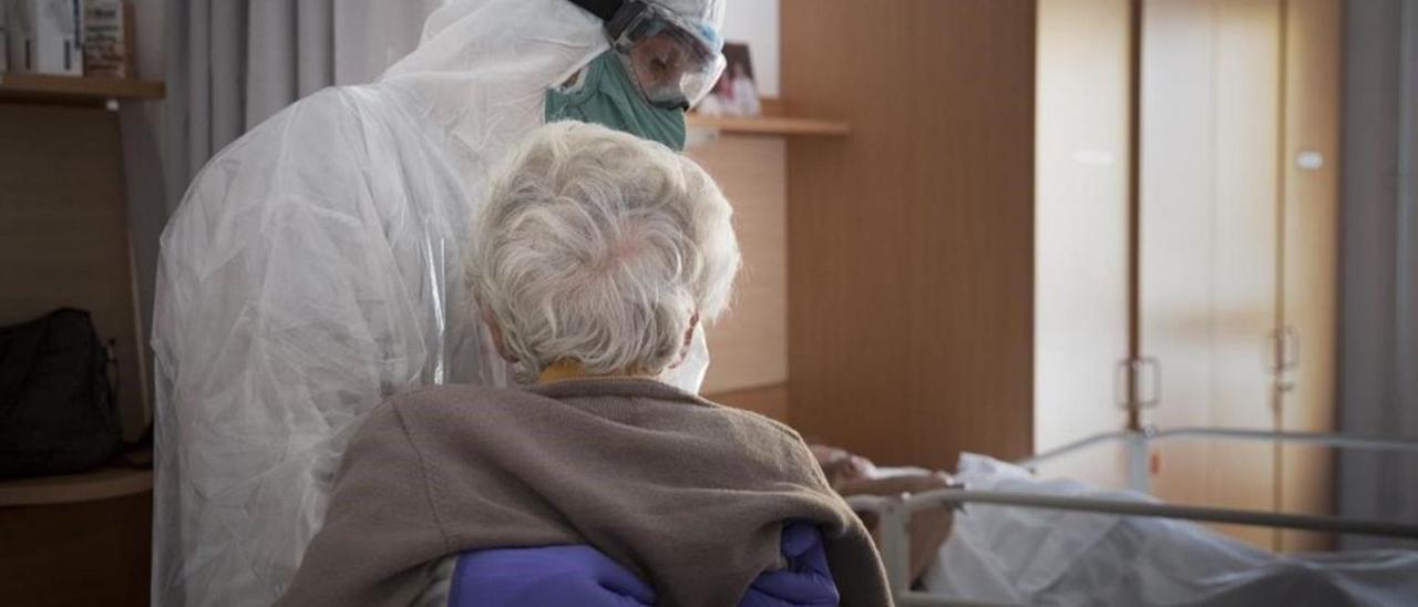 Imagen de archivo de un sanitario trasladando a una anciana durante la crisis provocada por el coronavirus. | | E.D.
