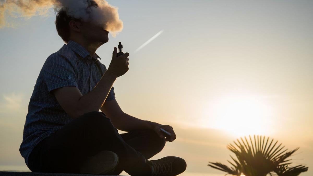 Un hombre, vapeando en la calle.