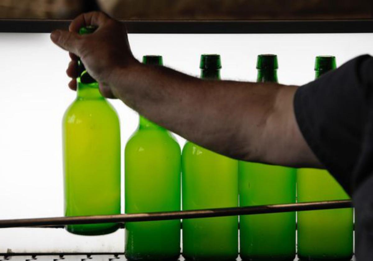 Arriba, varias botellas de sidra. Sobre estas líneas, la exposición de manzanas del festival. | L. M.