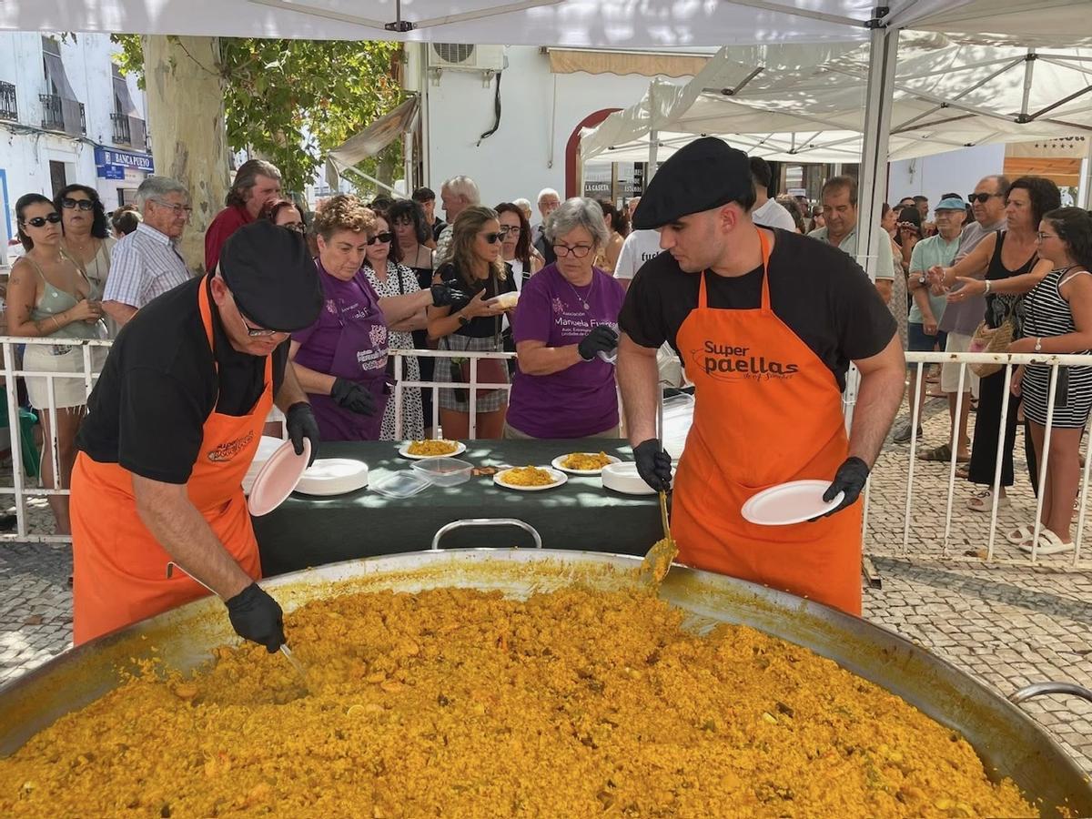 Reparto de una paella popular durante las celebraciones estivales de Villanueva del Fresno.