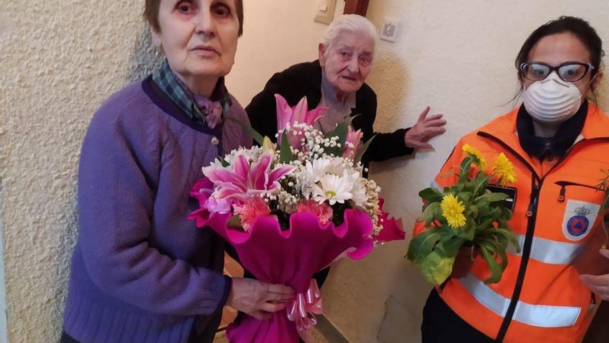La voluntaria de Protección Civil Zamora Lidia entrega una planta de Asprobub a Manuela en su 99 cumpleaños.