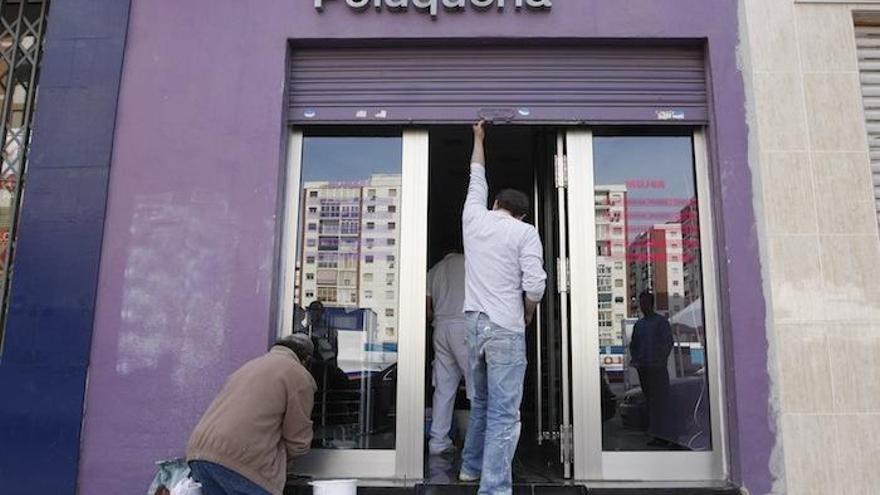 Un empresario prepara la puerta de su negocio.