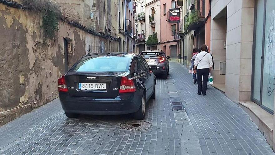 Cotxes i vianants circulant pel carrer de Sant Bartomeu
