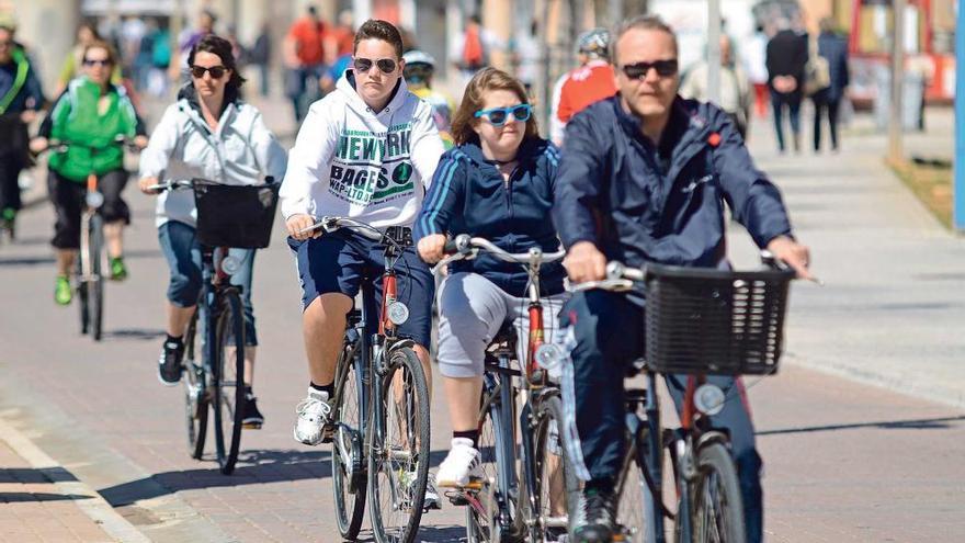 Un grupo de turistas aprovecha el sol primaveral para pasear en bicicleta.