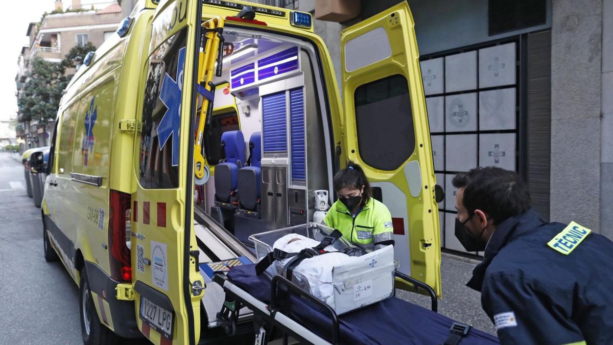 Tècnics d’emergències sanitàries durant el trasllat de la Clínica Girona. | ANIOL RESCLOSA
