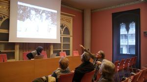 Gent gran a l’Arxiu Històric de Mataró identificant fotos antigues.