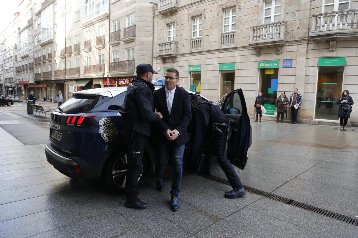 El acusado sale del coche policial