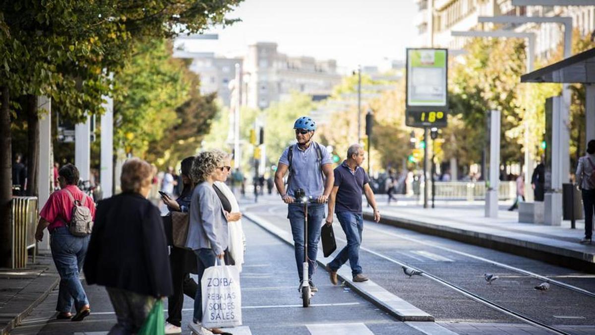 Un usuario de patinete eléctrico, con casco, circulando por el paseo Independencia de Zaragoza.