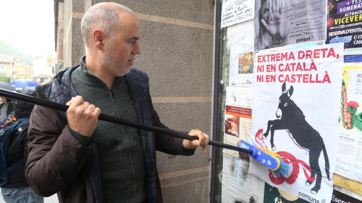 El cap de llista per Girona de Comuns Sumar, Eloi Badia, enganxa un cartell contra l'extrema dreta a Ripoll.