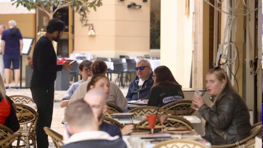 Un camarero atiende a clientes en un establecimiento hostelero de Málaga.