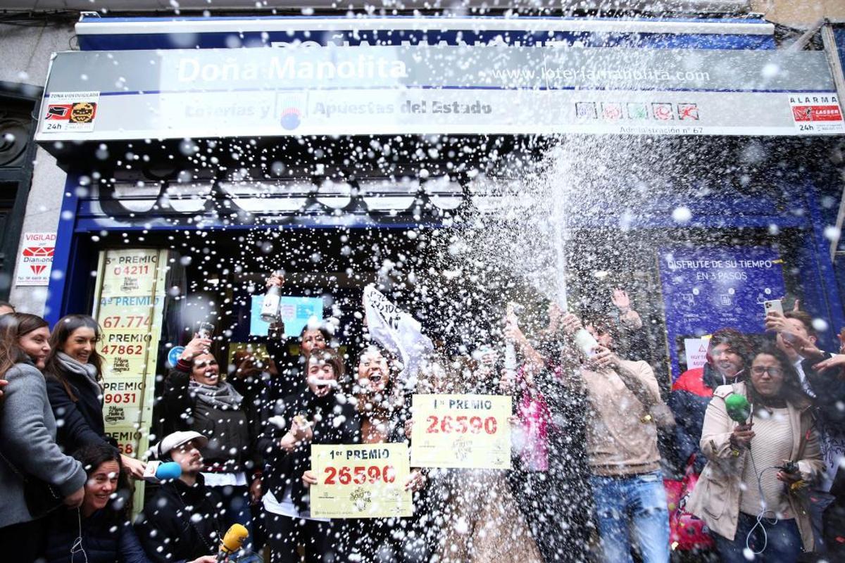 Agraciados por el Premio Gordo del Sorteo Extraordinario de Lotería de Navidad 2019 posan con el número premiado, el  26590, en la famosa administración de 'Doña Manolita'.