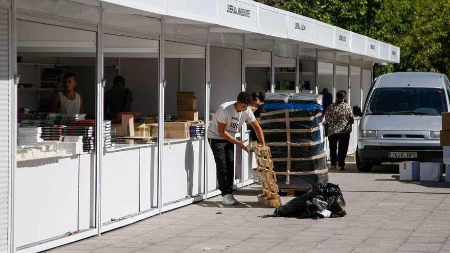 Varias personas se afanan en organizar las casetas de la feria.