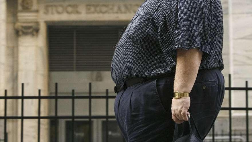 Un hombre obeso pasea por una calle neoyorquina.  // Efe