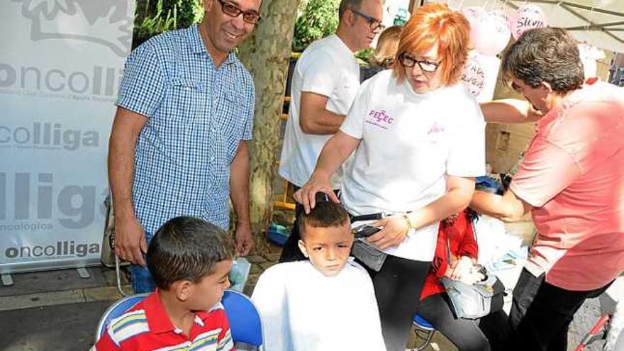 Una de les perruqueres talla els cabells a un nen, ahir a Crist Rei