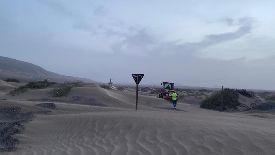 Una pala mecánica, ayer, aparta la arena en Famara