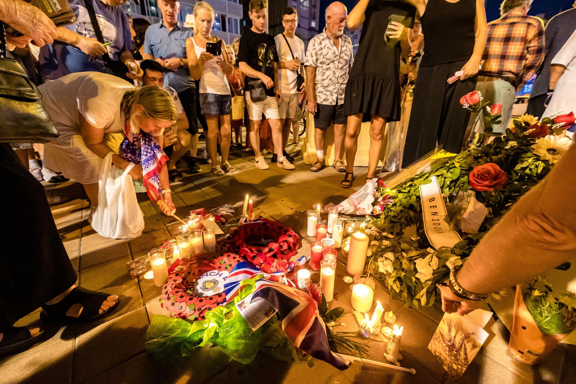 Británicos residentes y turistas de Benidorm rinden un sentido homenaje a Elizabeth II en el espacio habilitado por el Ayuntamiento en la zona inglesa de la ciudad.