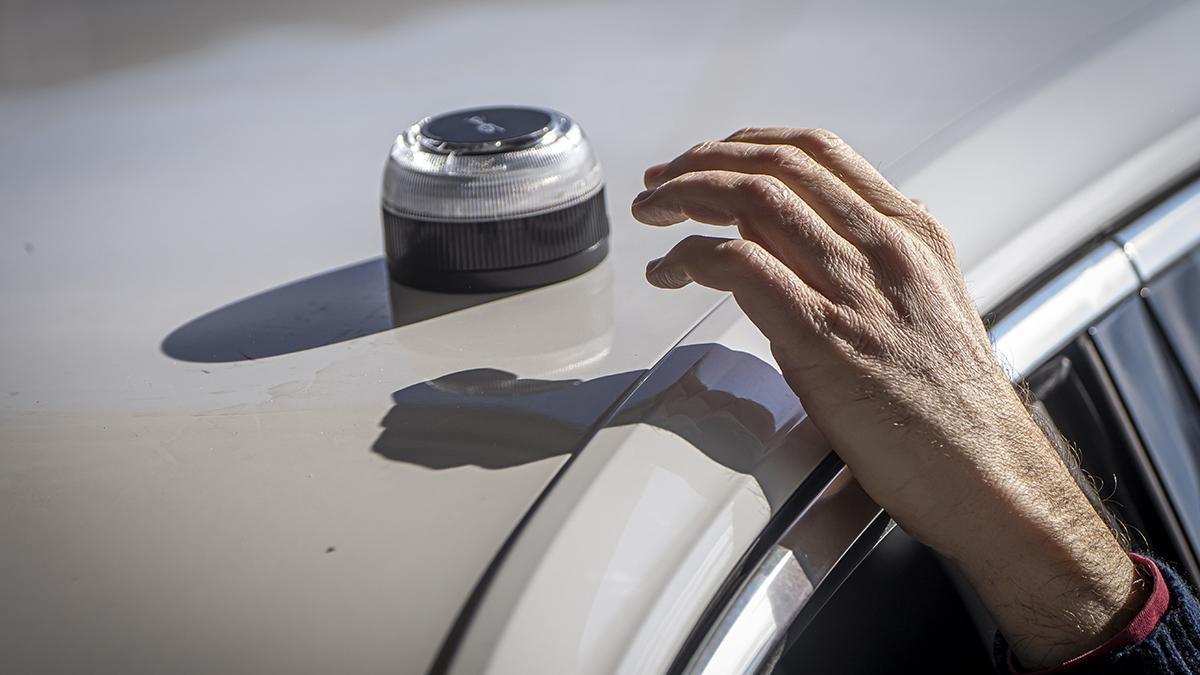 Un home col·loca una balisa V-16.