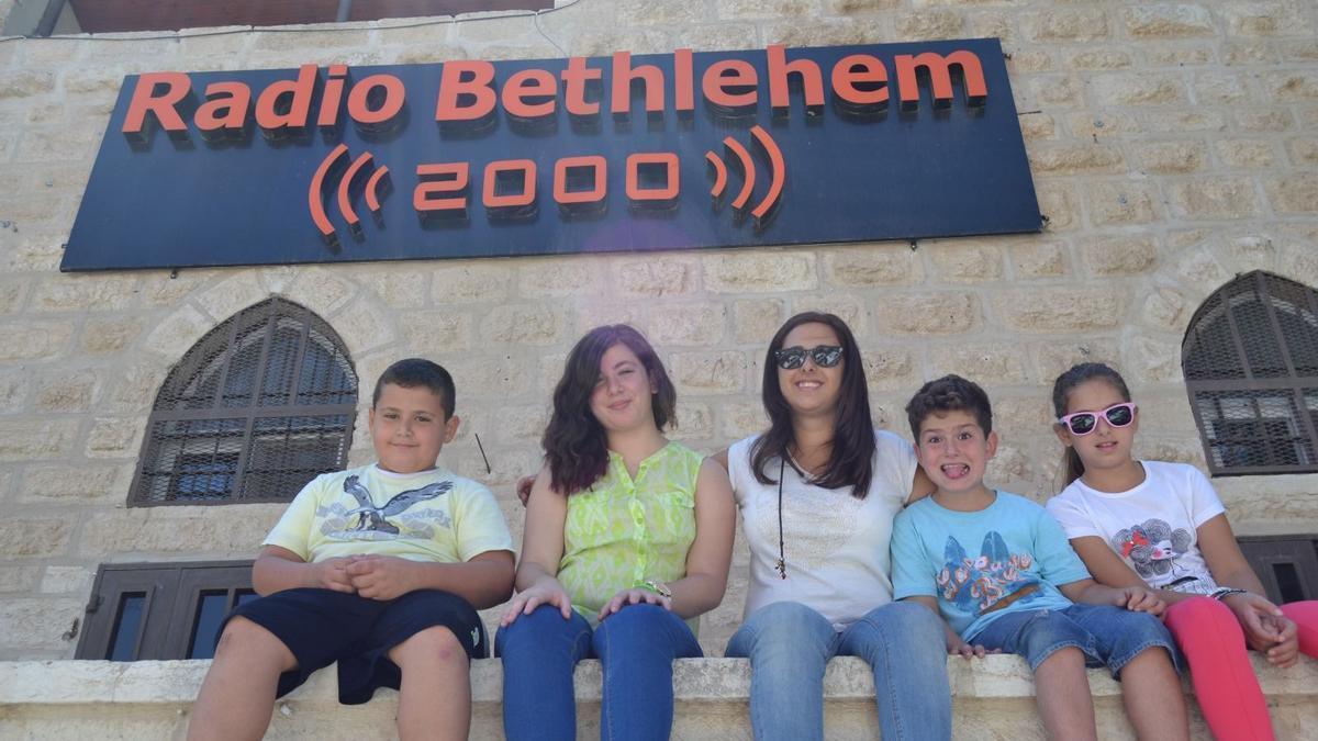 Nathaly, con sus sobrinos en la Radio de Belén en la que trabaja su hermano.