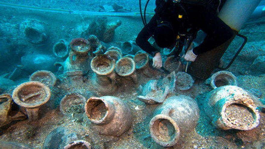 Un arqueòleg al costat de les 135 àmfores descobertes