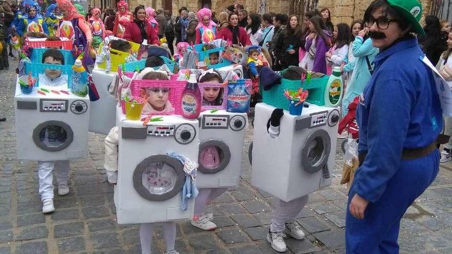 Un fontanero acompaña a las pequeñas lavadoras que desfilaron por las calles de la ciudad.