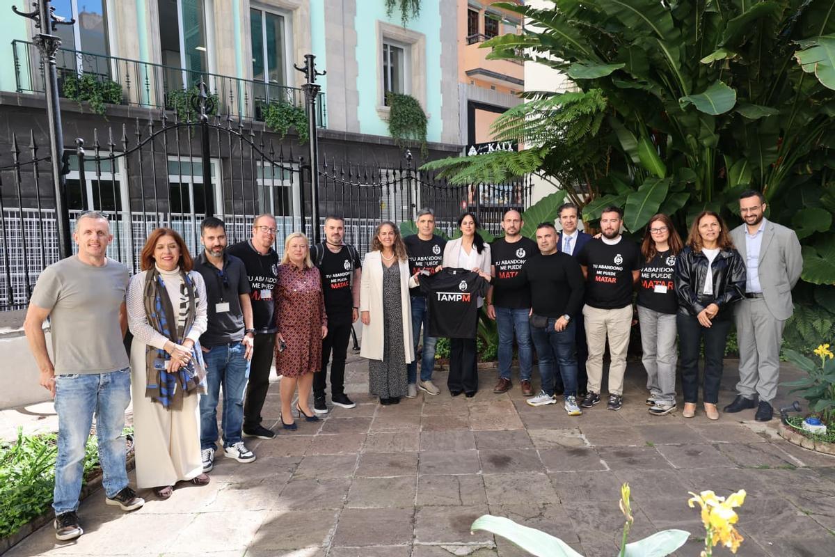 Foto de grupo de los portavoces parlamentarios con representantes del personal de los centros penitenciarios en el patio del Parlamento.