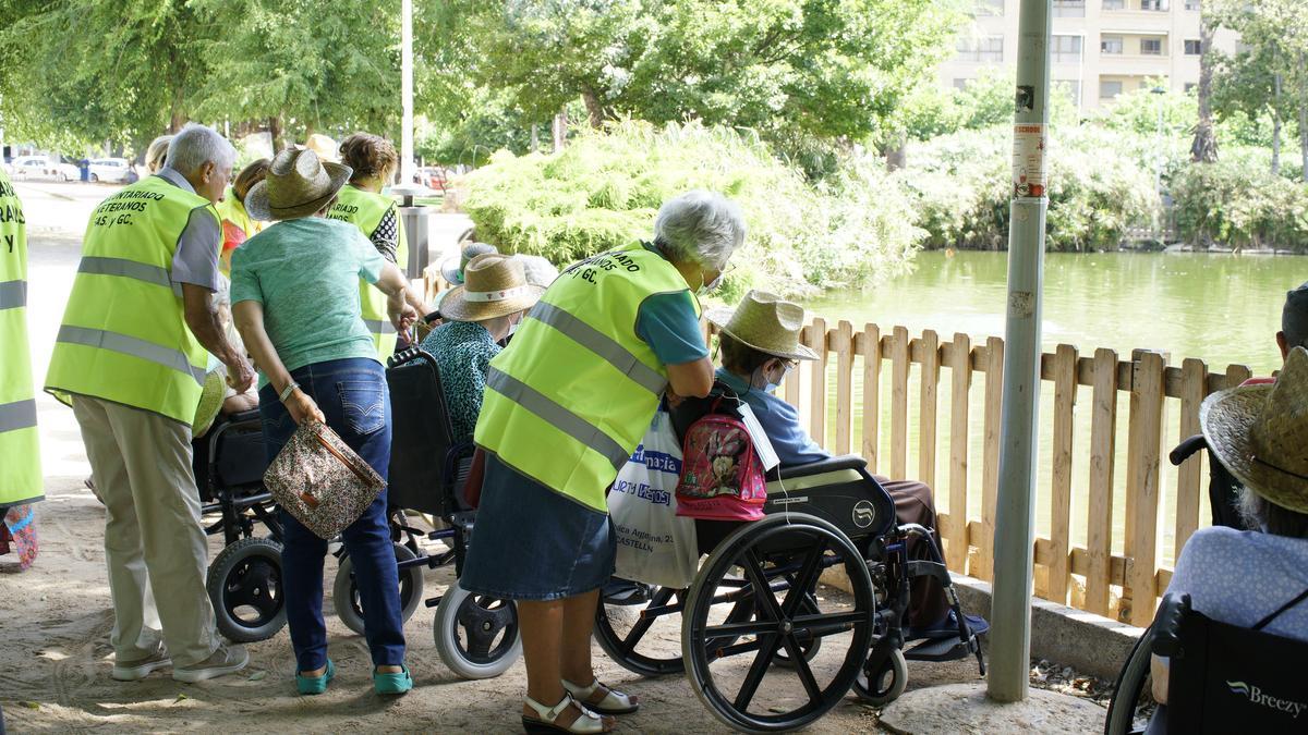 El grupo solidario, charlando con residentes, durante un paseo con vistas al estanque del parque del Oeste.