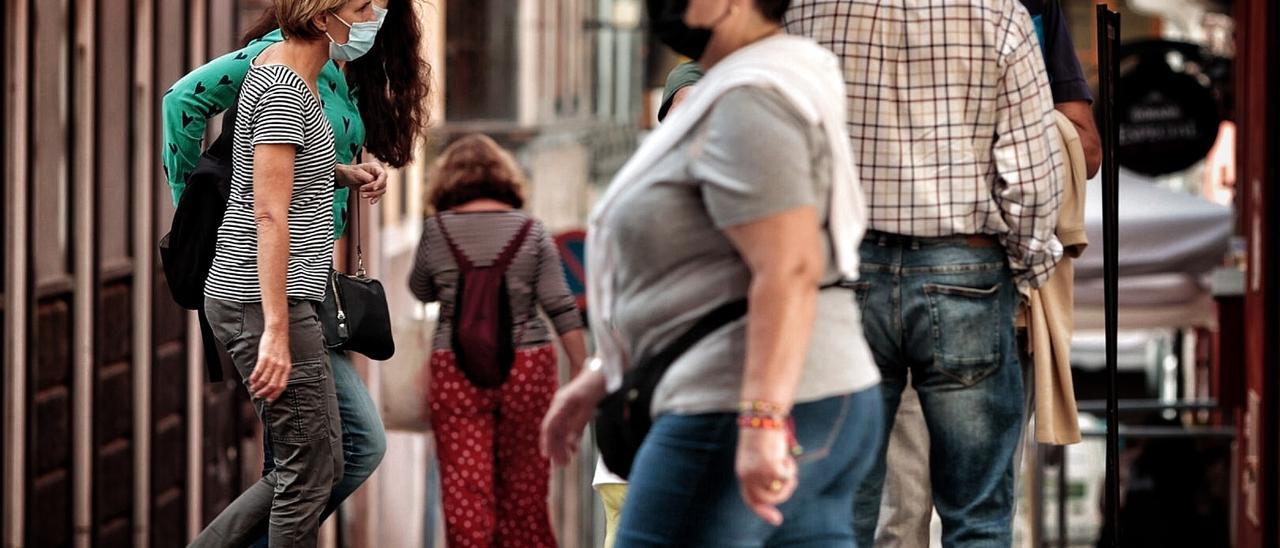 Varias personas con mascarilla transita por Santa Cruz de Tenerife.