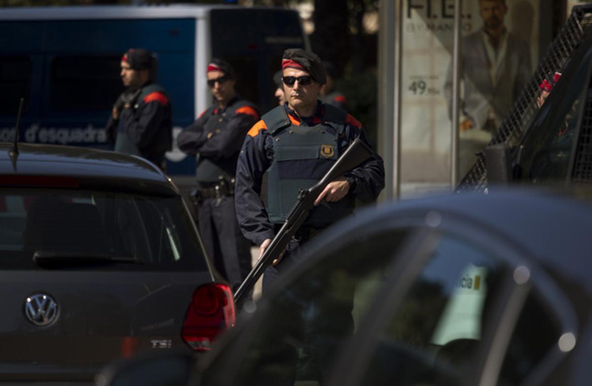 Un mosso d’esquadra armat inspecciona els voltants del lloc on se celebra la cimera financera.