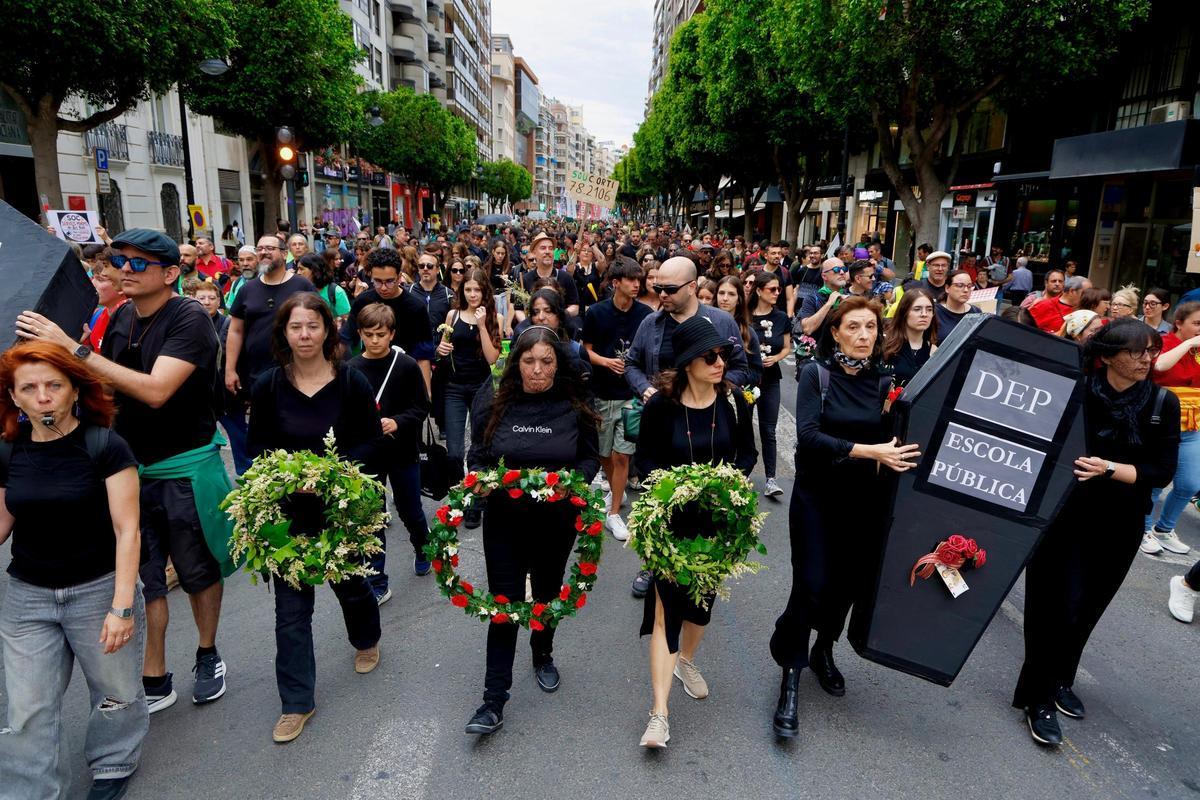 Manifestantes vestidos de luto para el "funeral" de la educación pública valenciana en la manifestación