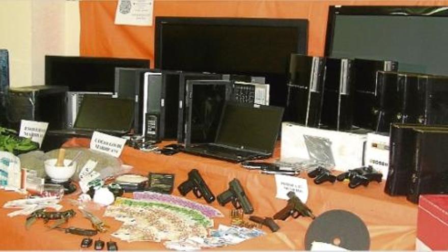 Tot el material requisat per la Policia Nacional, al fons els aparells electrònics estafats a l&#039;empresa i, en primer terme, les armes i els diners que tenien els delinqüents.