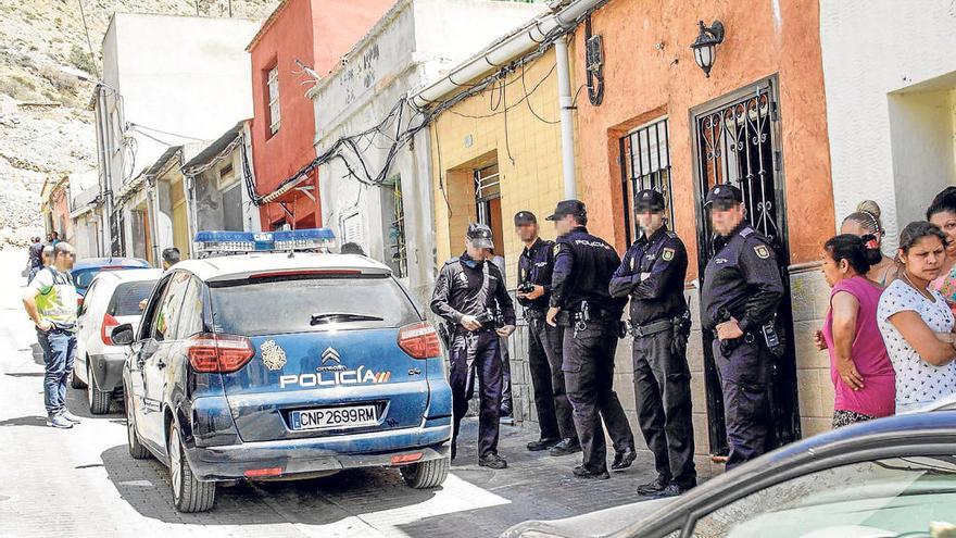 Varios policías custodian unas viviendas en el entorno de la sierra de Orihuela durante una redada.