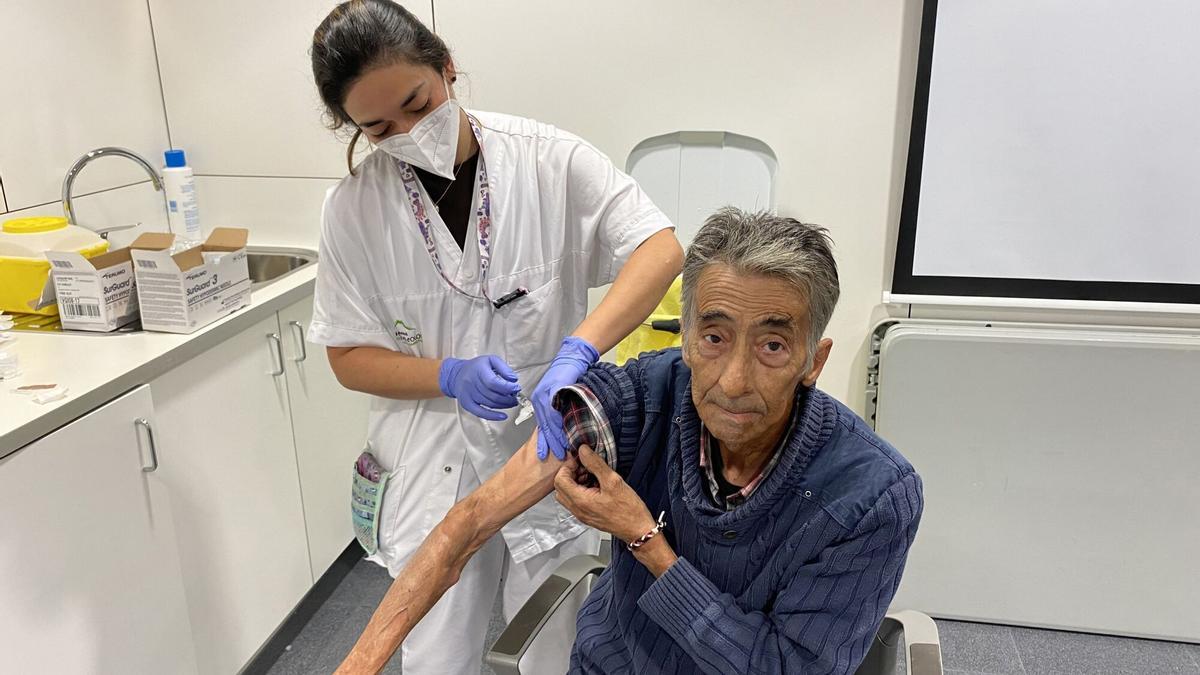 Un señor se vacuna de la gripe en un centro de salud.