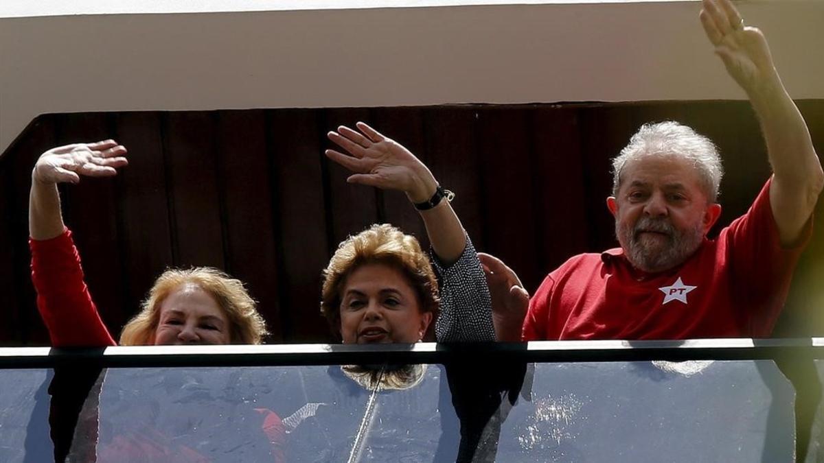 Lula (derecha), Rousseff y la esposa del expresidente, Marisa, saludan desde una ventana de la casa de la parella, en Sao Bernardo do Camopo (Brasil), el 5 de marzo.