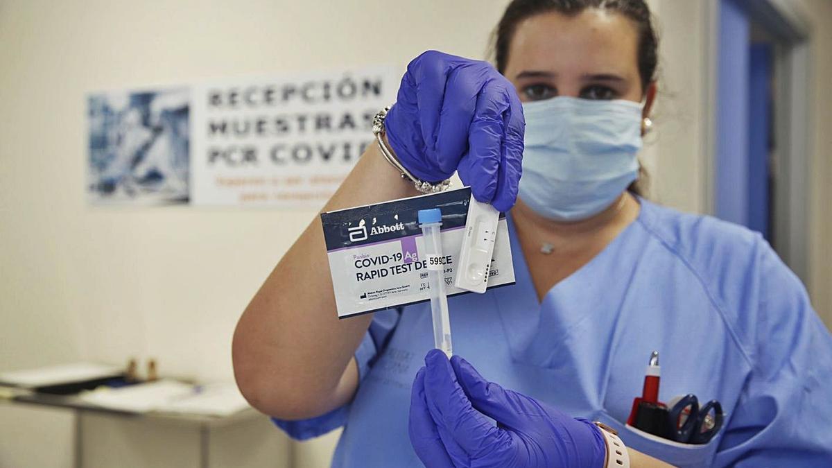 Una sanitaria del Hospital General muestra uno de los test rápidos distruibos por la Generalitat. | RAFA ARJONA