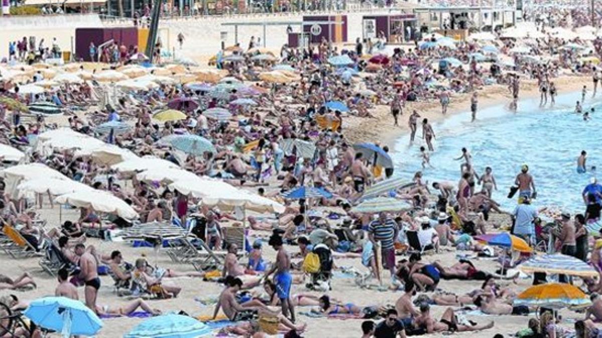 Hamacas y sombrillas de pago en la playa de Nova Icària, en Barcelona.