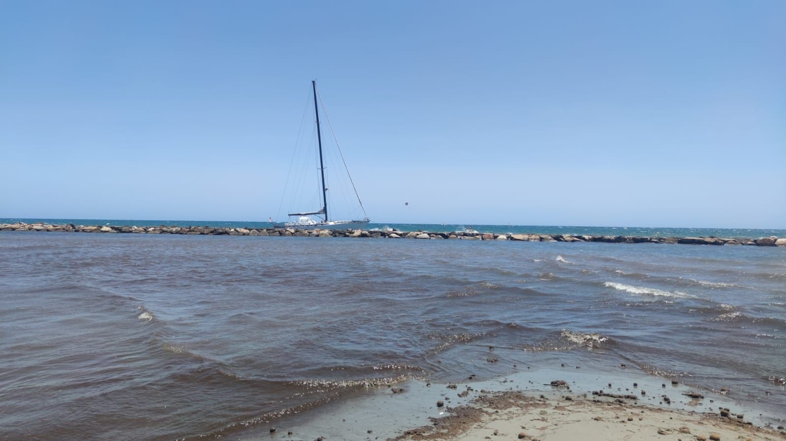 Un velero encalla en las rocas de la escollera de la playa del Cocó