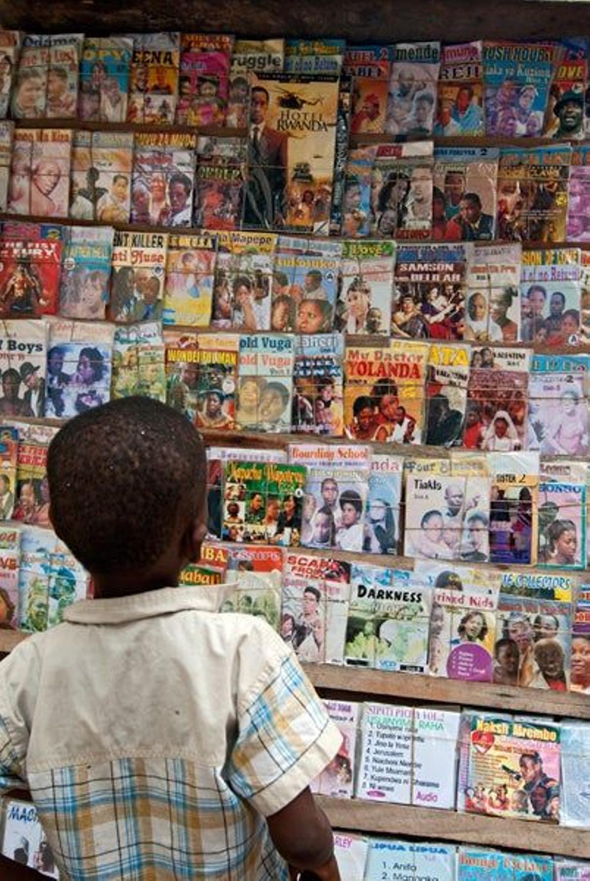 Niño mirando las revistas de un kiosko en el archipiélago de Lamu.