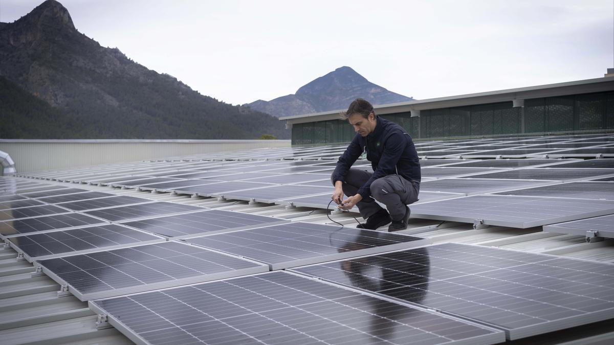 Un trabajador de Mercadona en la cubierta de una tienda con paneles solares.