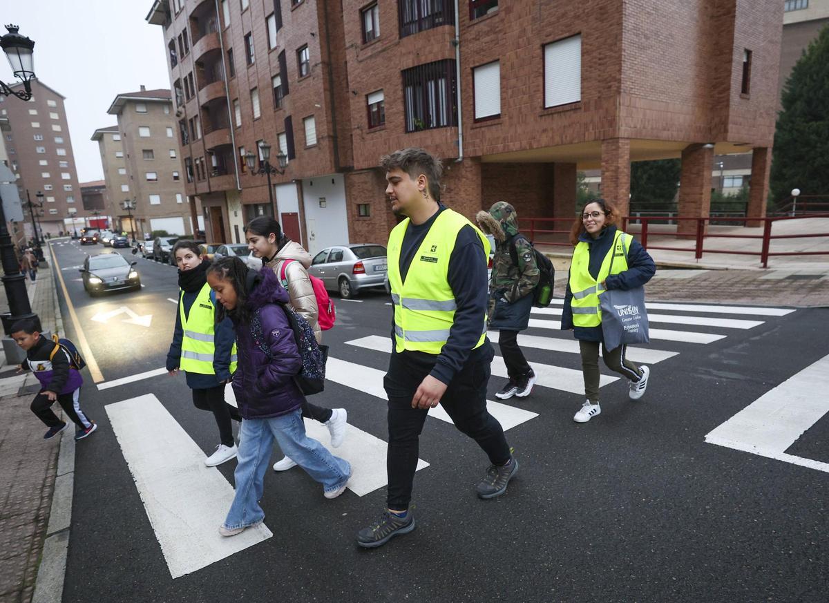 Los niños que vienen de Pumarín cruzan la calle junto a sus monitores.