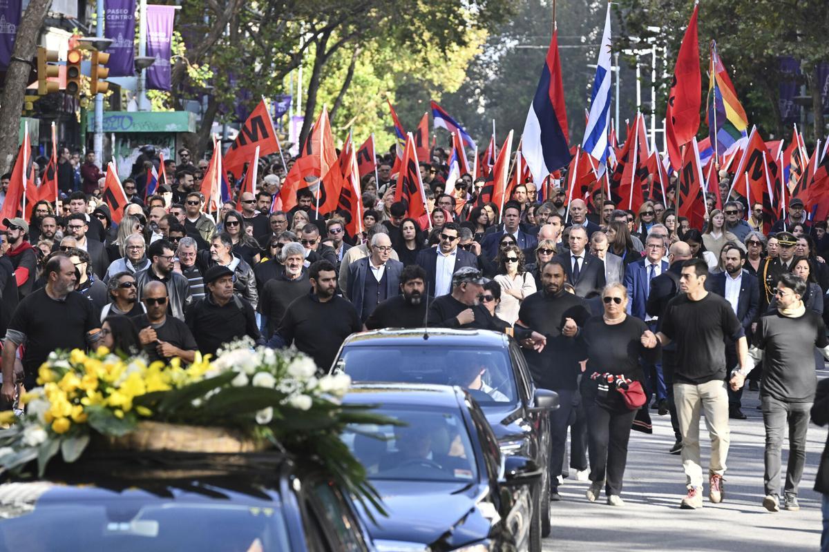 Supporters walk alongside the casket of former President Jose Mujica during his funeral procession from the presidential palace to the National Assembly in Montevideo, Uruguay, Wednesday, May 14, 2025. (AP Photo/Santiago Mazzarovich)