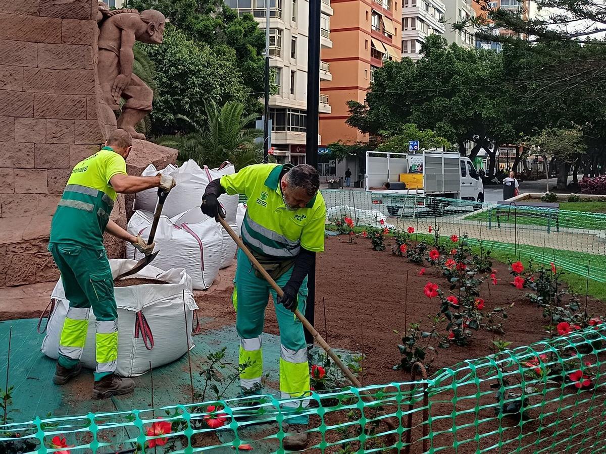 Trabajadores de Parques y Jardines replantan los alrededores de la escultura de Luis Montull, en la plaza de España.