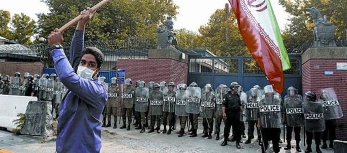 Un ciutadà iranià, seguidor del president oficialment reelecte, Mahmud Ahmadinejad, oneja una bandera del seu país davant l’ambaixada britànica a Teheran, molt protegida. Un ciutadà iranià, seguidor del president oficialment reelecte, Mahmud Ahmadinejad, oneja una bandera del seu país davant l’ambaixada britànica a Teheran, molt protegida.