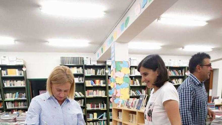Miembros de la asociación de padres, ayer, en la biblioteca del instituto, entre los libros que reciben de forma gratuita los alumnos.