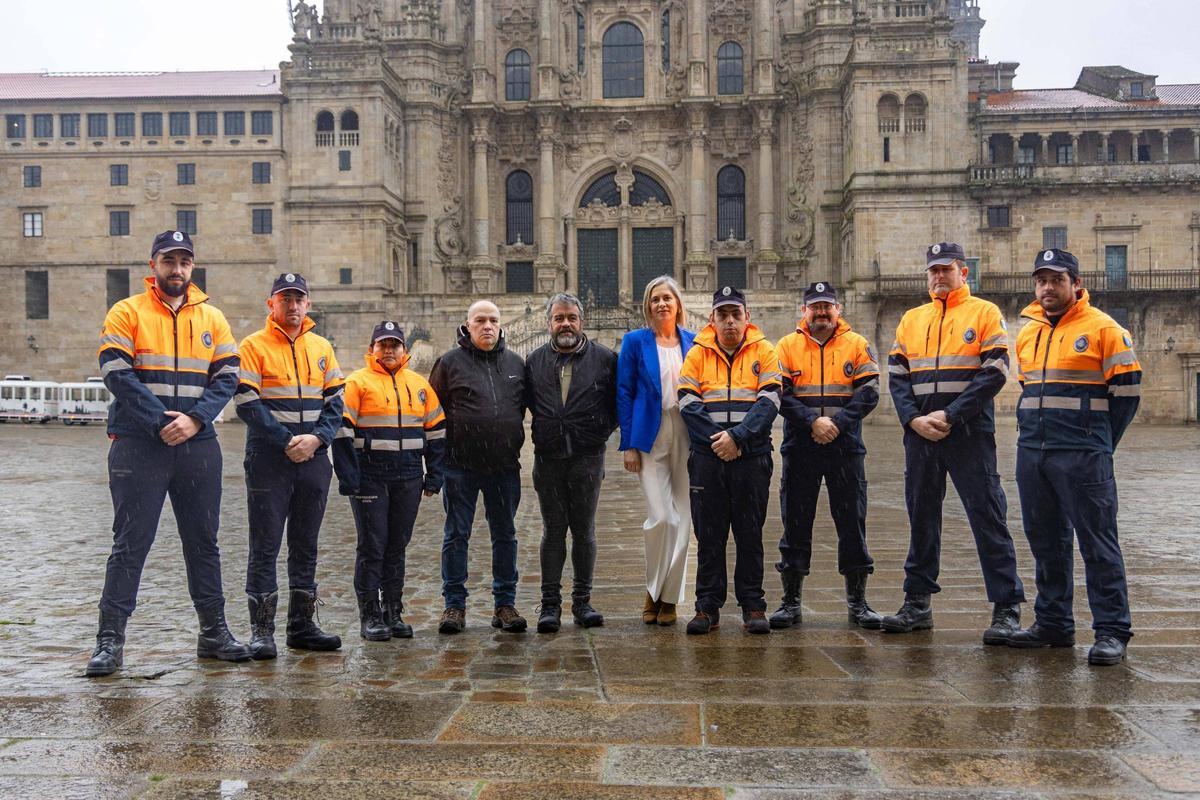Voluntarios actuales y veteranos de Protección Civil de Santiago con Begoña delRío, en el centro, en la praza do Obradoiro de Santiago.