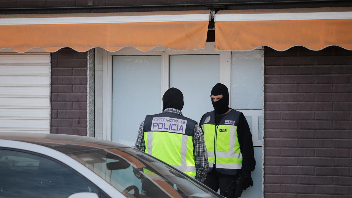 Dos agentes de la Policía Nacional en la puerta de un domicilio en Melilla.