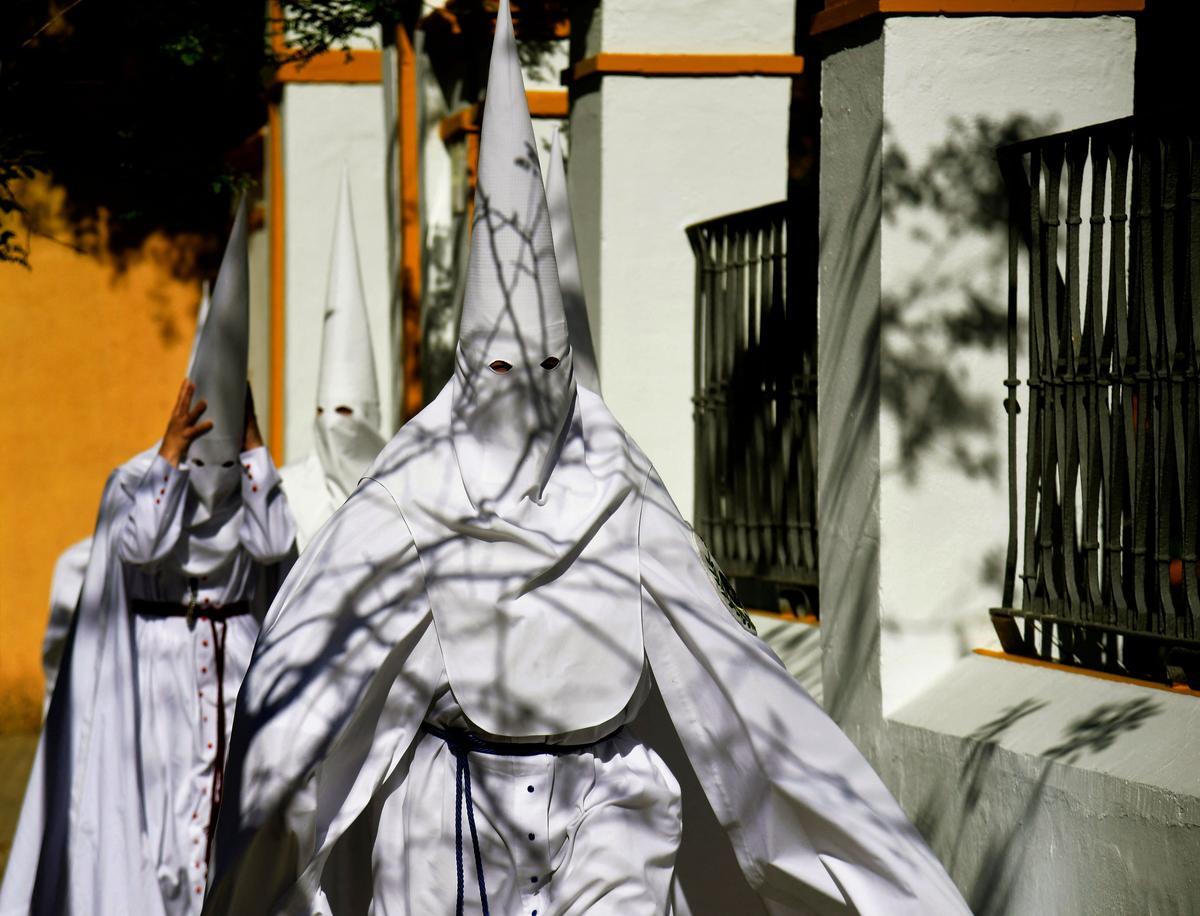 Penitentes de la hermandad de La Paz participan en la procesión del Domingo de Ramos en Sevilla