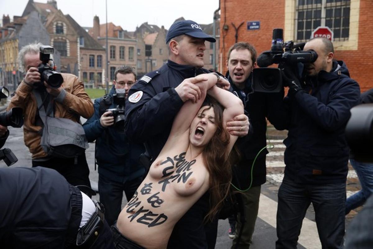 La policia francesa s’emporta arrossegant una de les activistes de Femen que ha assaltat el vehicle de Strauss-Kahn a l’arribar al jutjat, aquest dimarts.