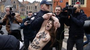 La policia francesa s’emporta arrossegant una de les activistes de Femen que ha assaltat el vehicle de Strauss-Kahn a l’arribar al jutjat, aquest dimarts.